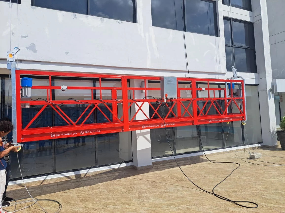 Guindola eléctrica instalada frente a una fachada de vidrio